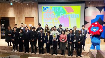 group photo, people are standing in front of a screen, osaka sdgs forum